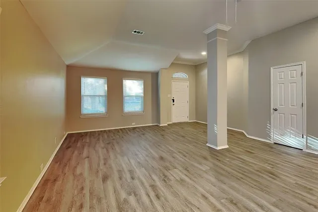 a view of a kitchen with wooden floor and stainless steel appliances