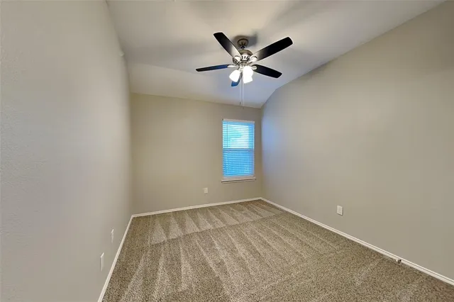 an empty room with closet and a chandelier fan