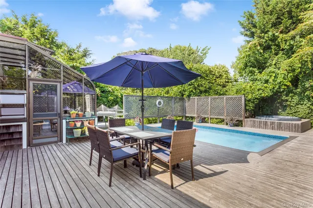 a view of backyard with seating space and wooden fence