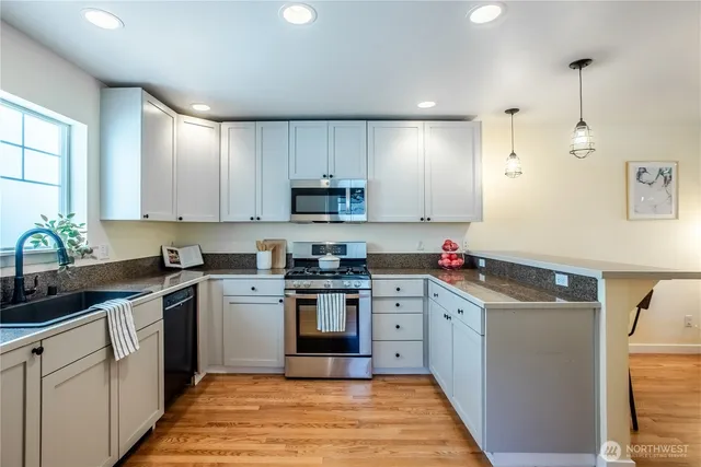 a kitchen with a sink a stove and cabinets