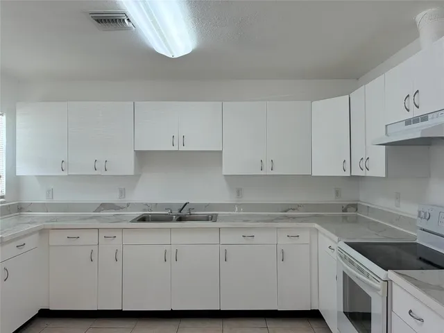 a kitchen with granite countertop white cabinets and white appliances