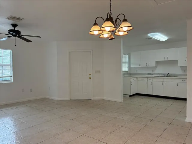 a view of a kitchen with a sink and chandelier