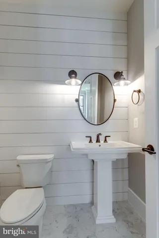 an empty room with wooden floor fireplace and windows