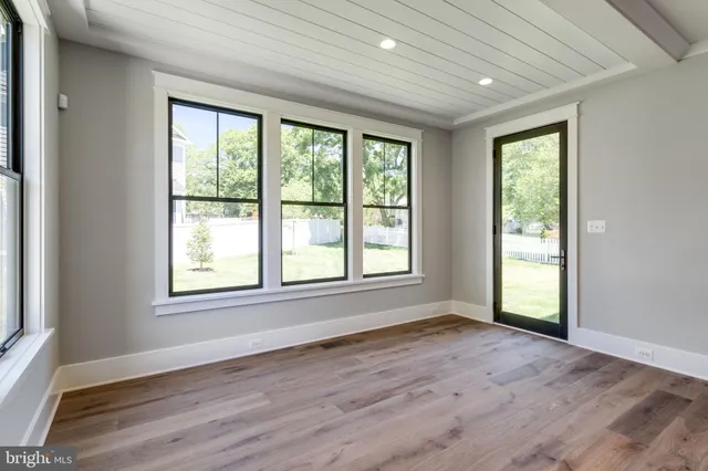a view of a hallway with wooden floor and a bathroom
