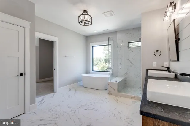 a bathroom with a double vanity sink large mirror and a bathtub