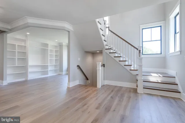 a view of a hallway with wooden floor and a kitchen