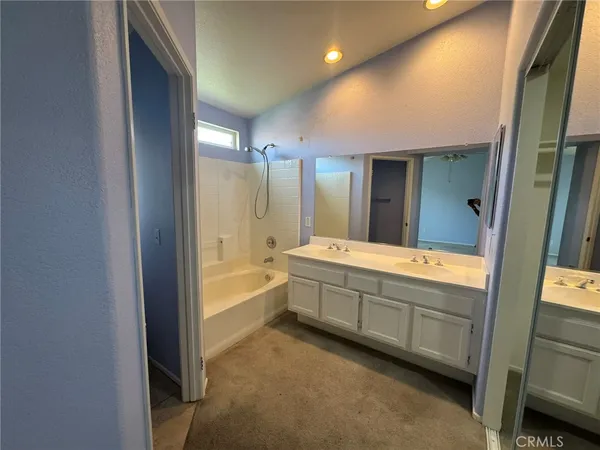 a bathroom with a tub sink shower and mirror