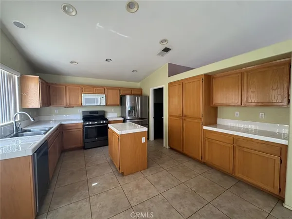 a kitchen with refrigerator cabinets and wooden floor