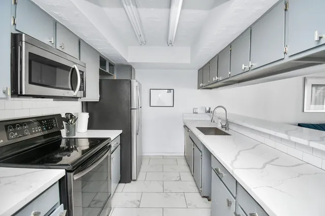 a kitchen with stainless steel appliances granite countertop a sink and a stove