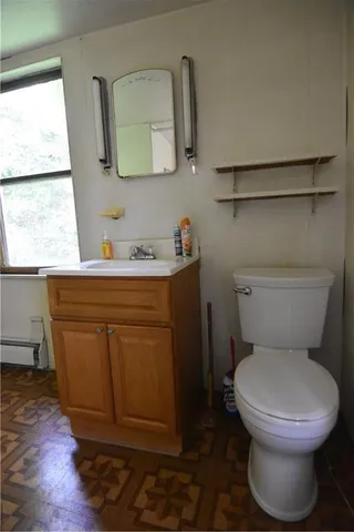 a bathroom with a toilet a sink and a window