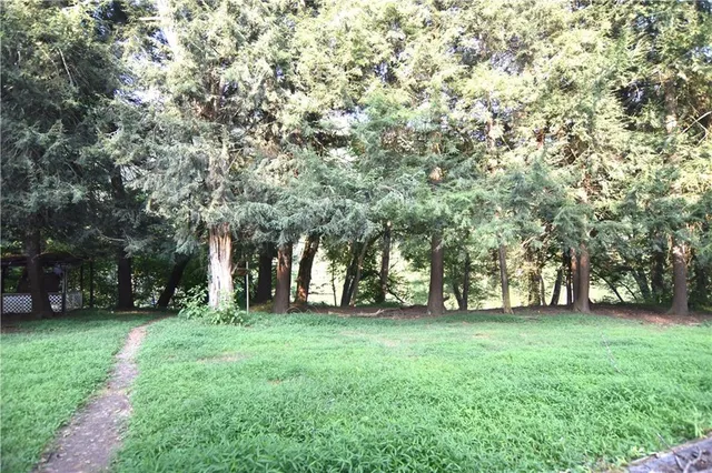 an aerial view of residential house with outdoor space and trees around