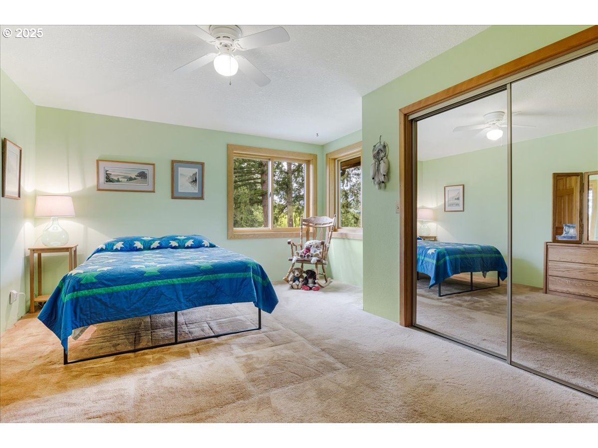 18258 South Dillman Road Oregon City, OR 97045 - Photo 23 of 43 a bedroom with a large bed and a chandelier