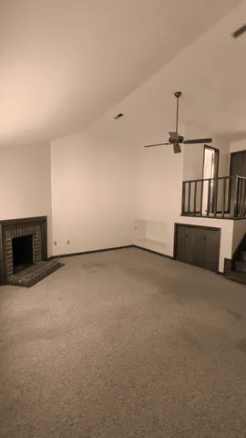 an empty room with fireplace and book shelf