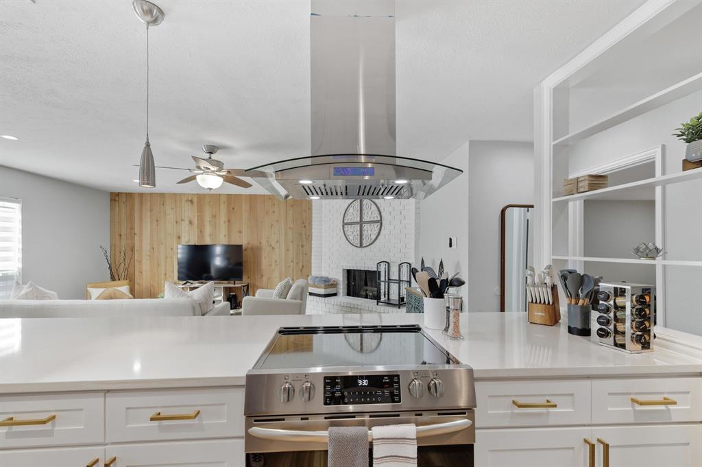 5112 Arbor Glen Road The Colony, TX 75056 - Photo 13 of 40 Kitchen with stainless steel range, pendant lighting, island range hood, and white cabinets