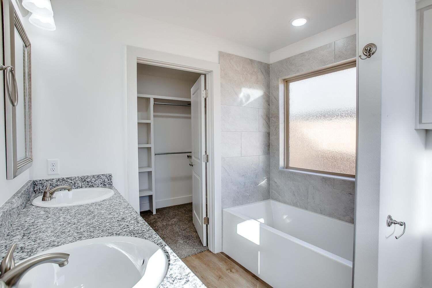 811 North 4th Street Wolfforth, TX 79382 - Photo 11 of 18 a bathroom with a granite countertop sink toilet and shower
