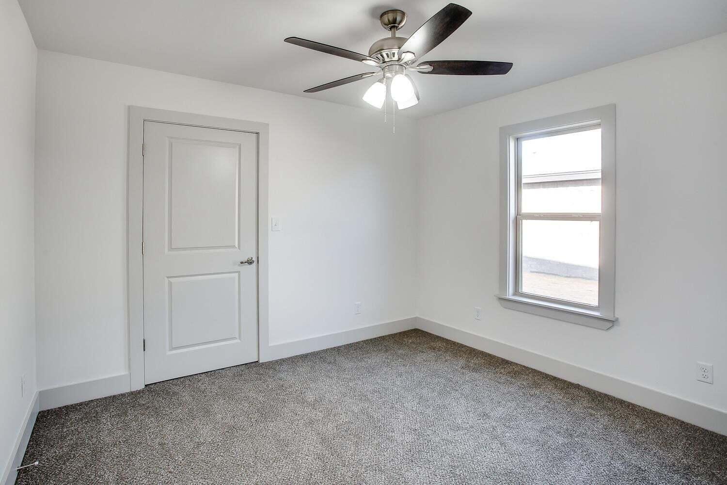 811 North 4th Street Wolfforth, TX 79382 - Photo 15 of 18 an empty room with windows and fan