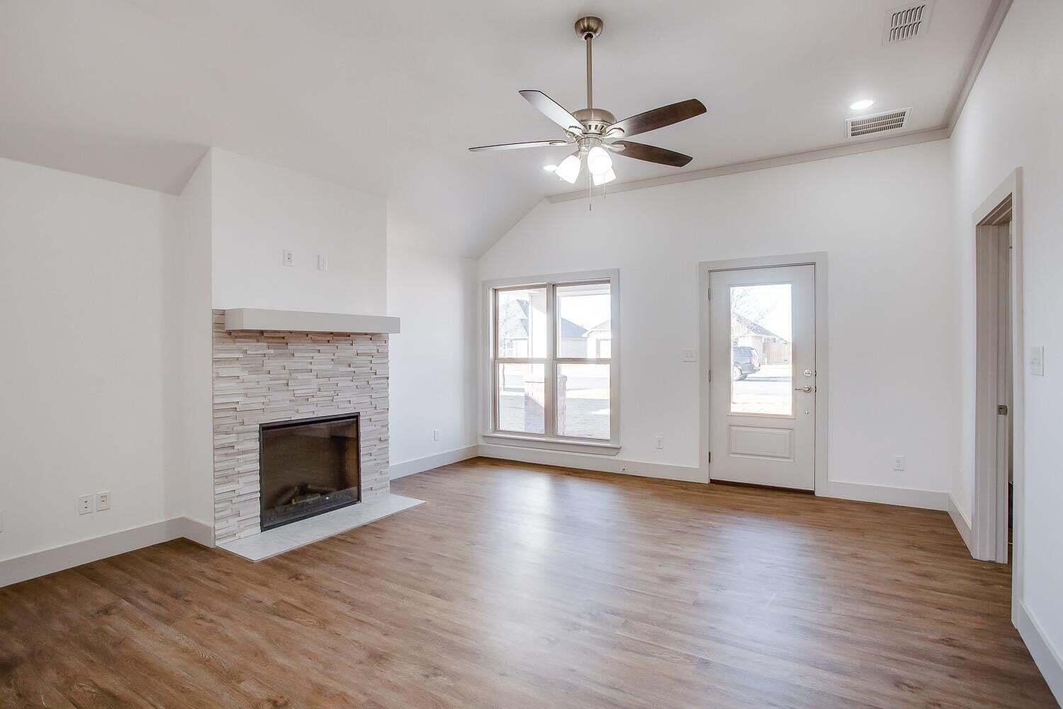 811 North 4th Street Wolfforth, TX 79382 - Photo 3 of 18 a view of an empty room with wooden floor fireplace and a window