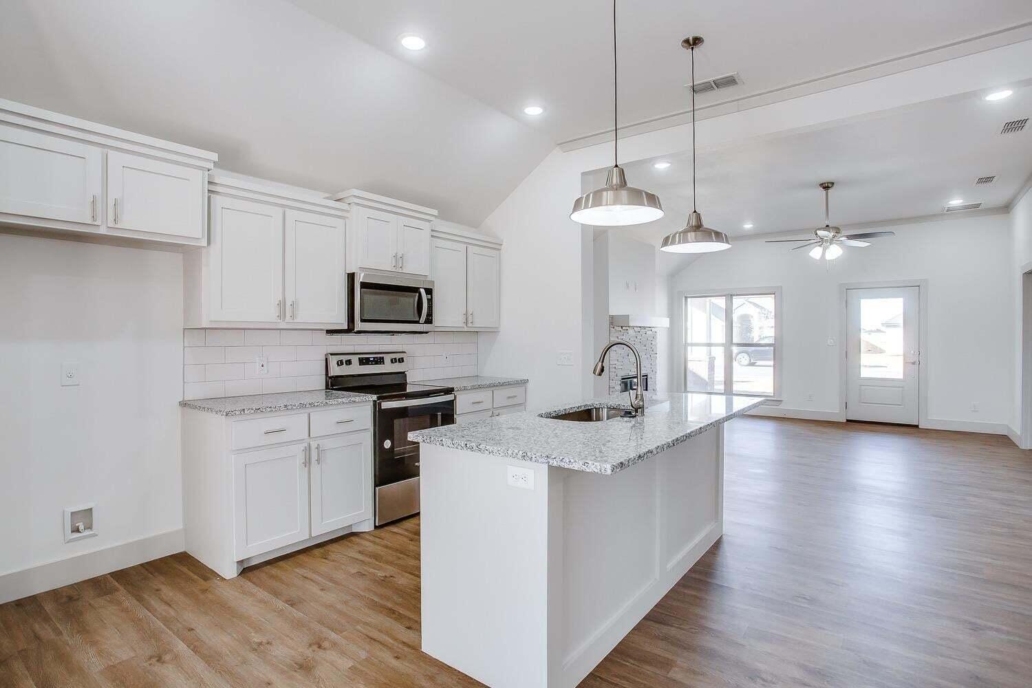 811 North 4th Street Wolfforth, TX 79382 - Photo 6 of 18 a kitchen with a stove a sink and a refrigerator