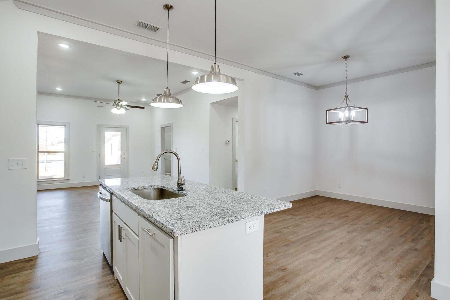 811 North 4th Street Wolfforth, TX 79382 - Photo 8 of 18 a kitchen with granite countertop a sink cabinets and wooden floor
