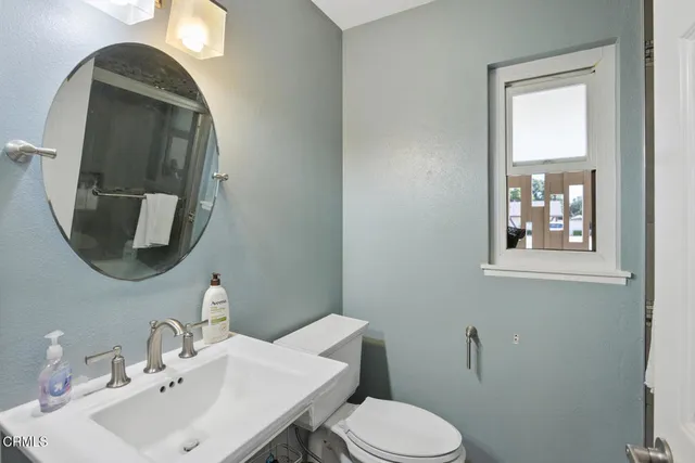 a bathroom with a toilet sink and mirror