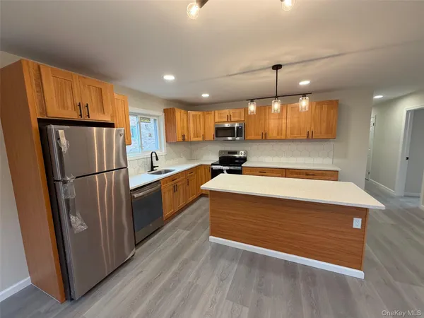 a kitchen with stainless steel appliances granite countertop a refrigerator a sink and a stove