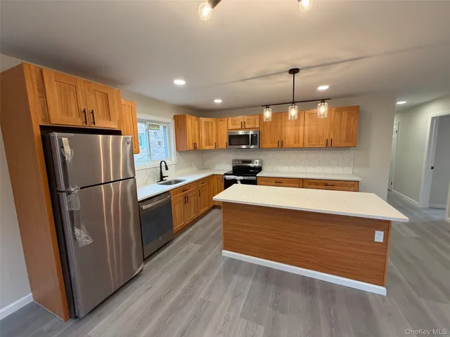 a kitchen with stainless steel appliances granite countertop a refrigerator a sink and a stove