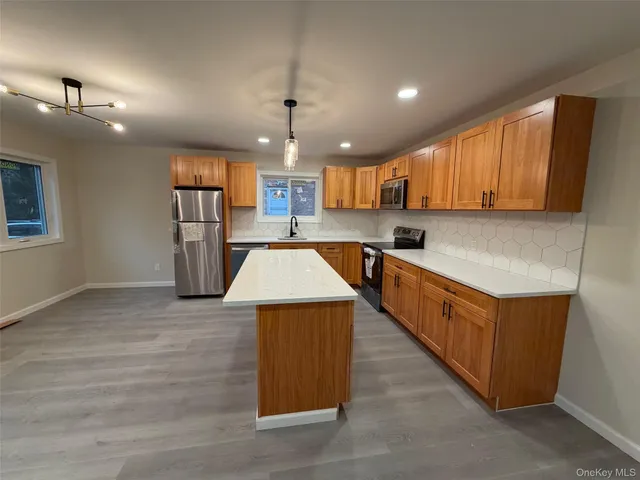 a kitchen with stainless steel appliances granite countertop a sink dishwasher a refrigerator and a stove
