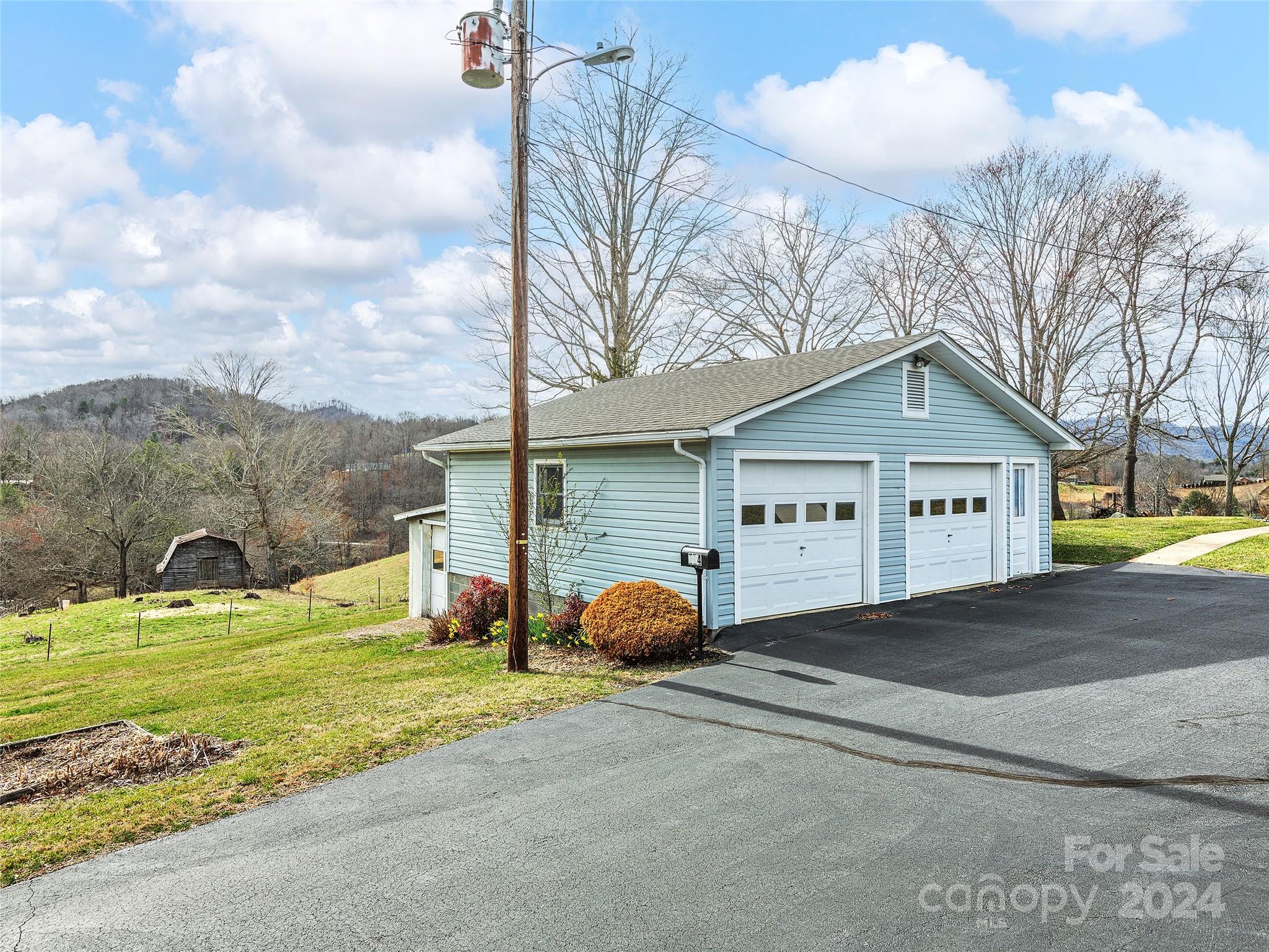 704 Mulberry Street Clyde, NC 28721 - Photo 28 of 36 a view of a house with a big yard and large trees