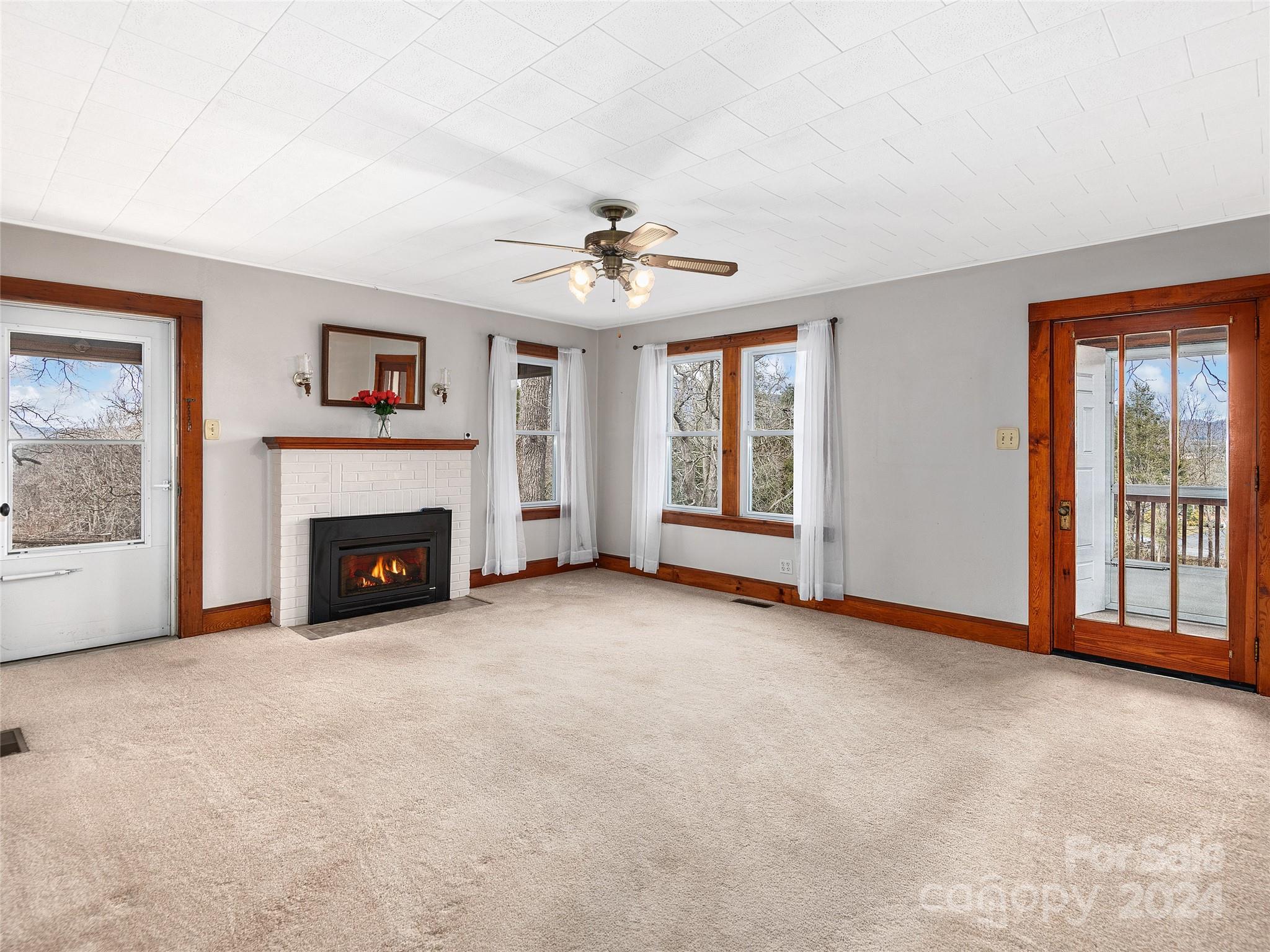 704 Mulberry Street Clyde, NC 28721 - Photo 3 of 36 wooden floor fireplace and windows in an empty room