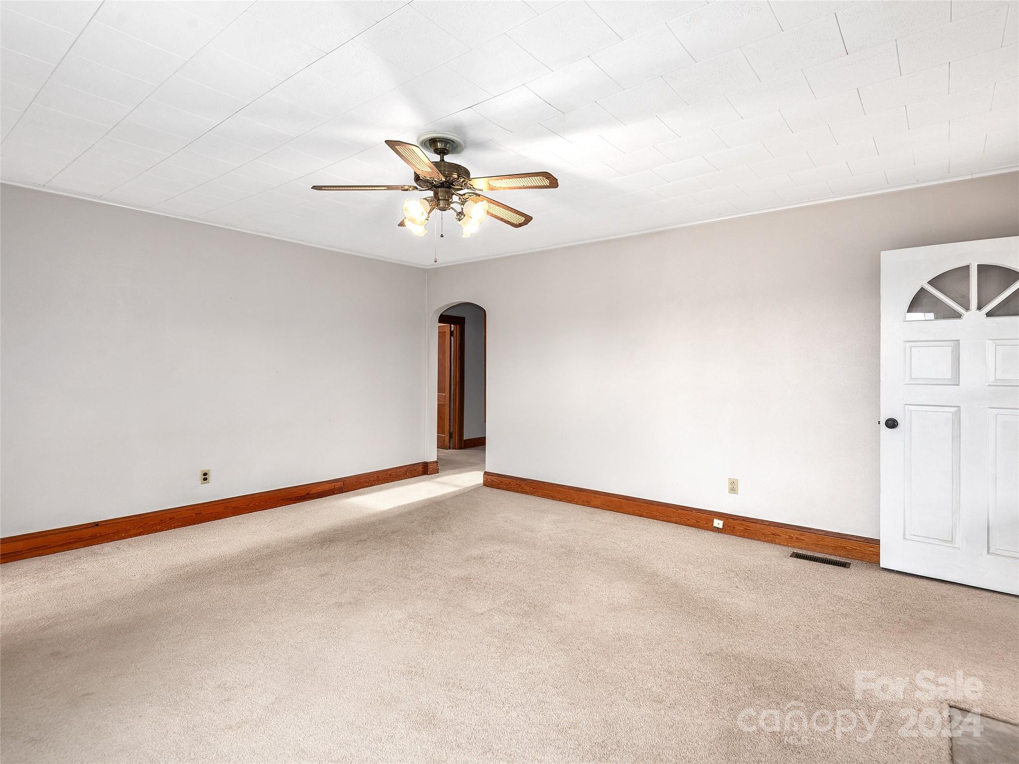 704 Mulberry Street Clyde, NC 28721 - Photo 5 of 36 an empty room with a empty space and a ceiling fan