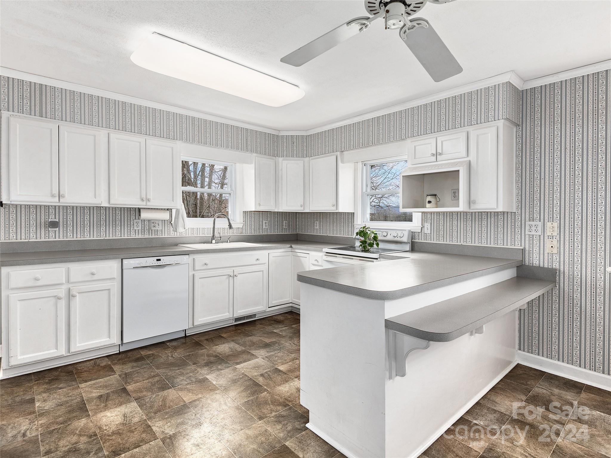 704 Mulberry Street Clyde, NC 28721 - Photo 6 of 36 a kitchen with stainless steel appliances granite countertop a sink a stove a refrigerator cabinets and a window