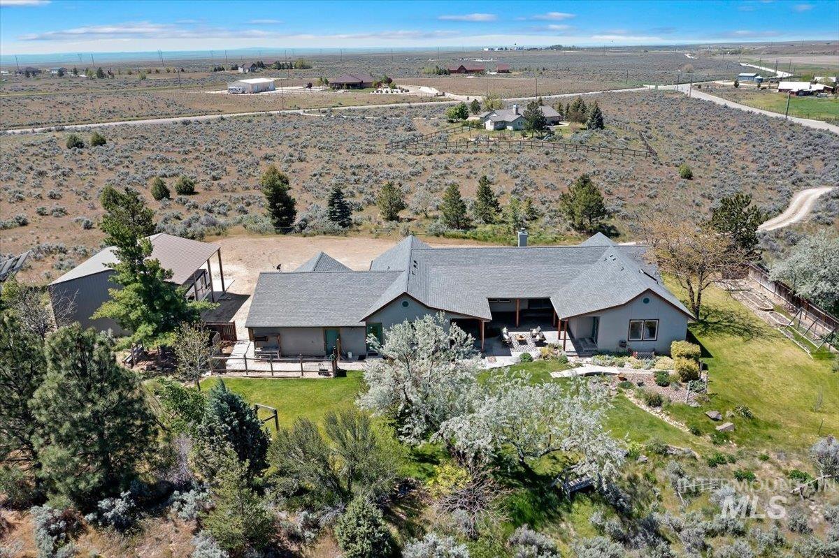 147 East Indian Crk Road Boise, ID 83716 - Photo 41 of 43 Ranch-style residence featuring an expansive shingle roofline, a covered outdoor patio, and a separate outbuilding with a metal roof