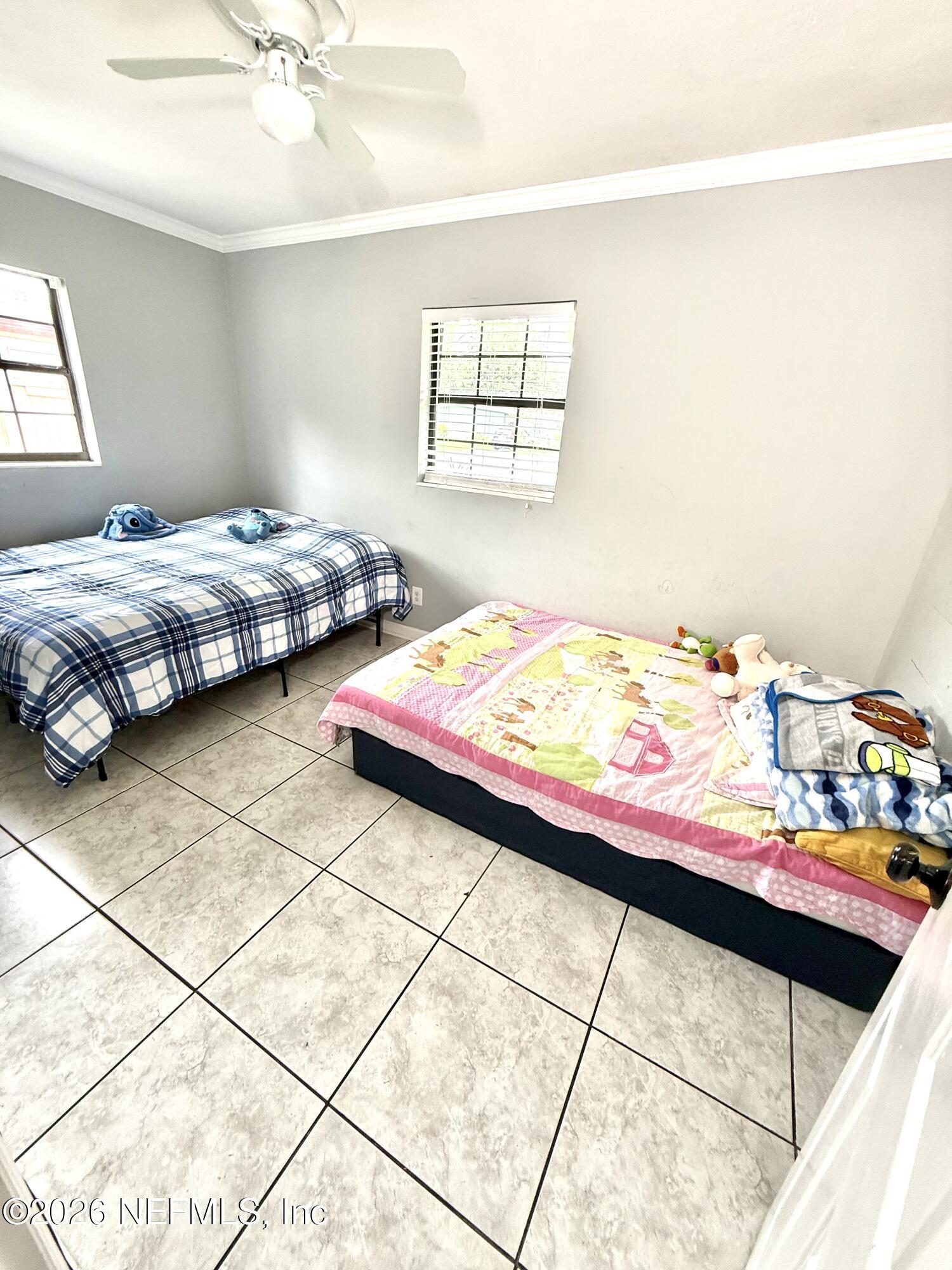 10162 Herndon Road Jacksonville, FL 32246 - Photo 13 of 31 a bedroom with a bed and a window