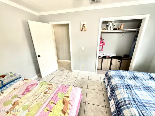 a bed sitting in a bedroom next to a window