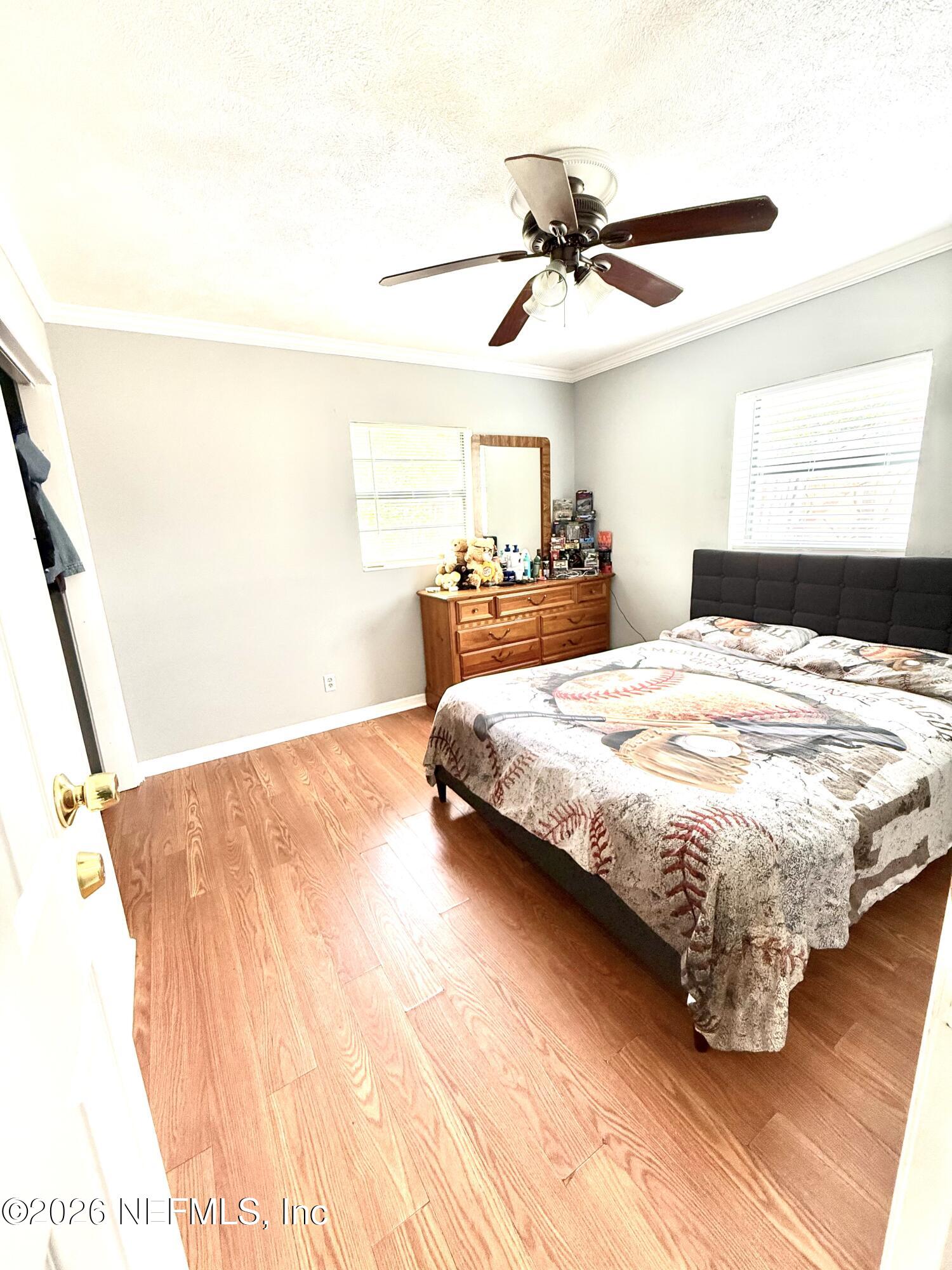 10162 Herndon Road Jacksonville, FL 32246 - Photo 15 of 31 a bedroom with a bed and a ceiling fan