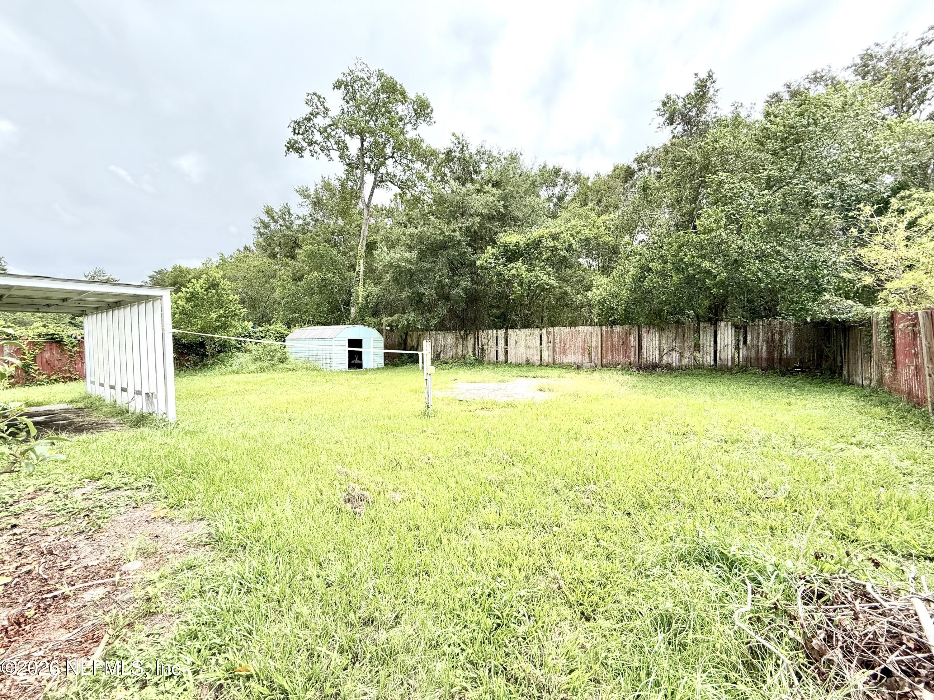 10162 Herndon Road Jacksonville, FL 32246 - Photo 20 of 31 a view of a swimming pool with a yard and a large tree