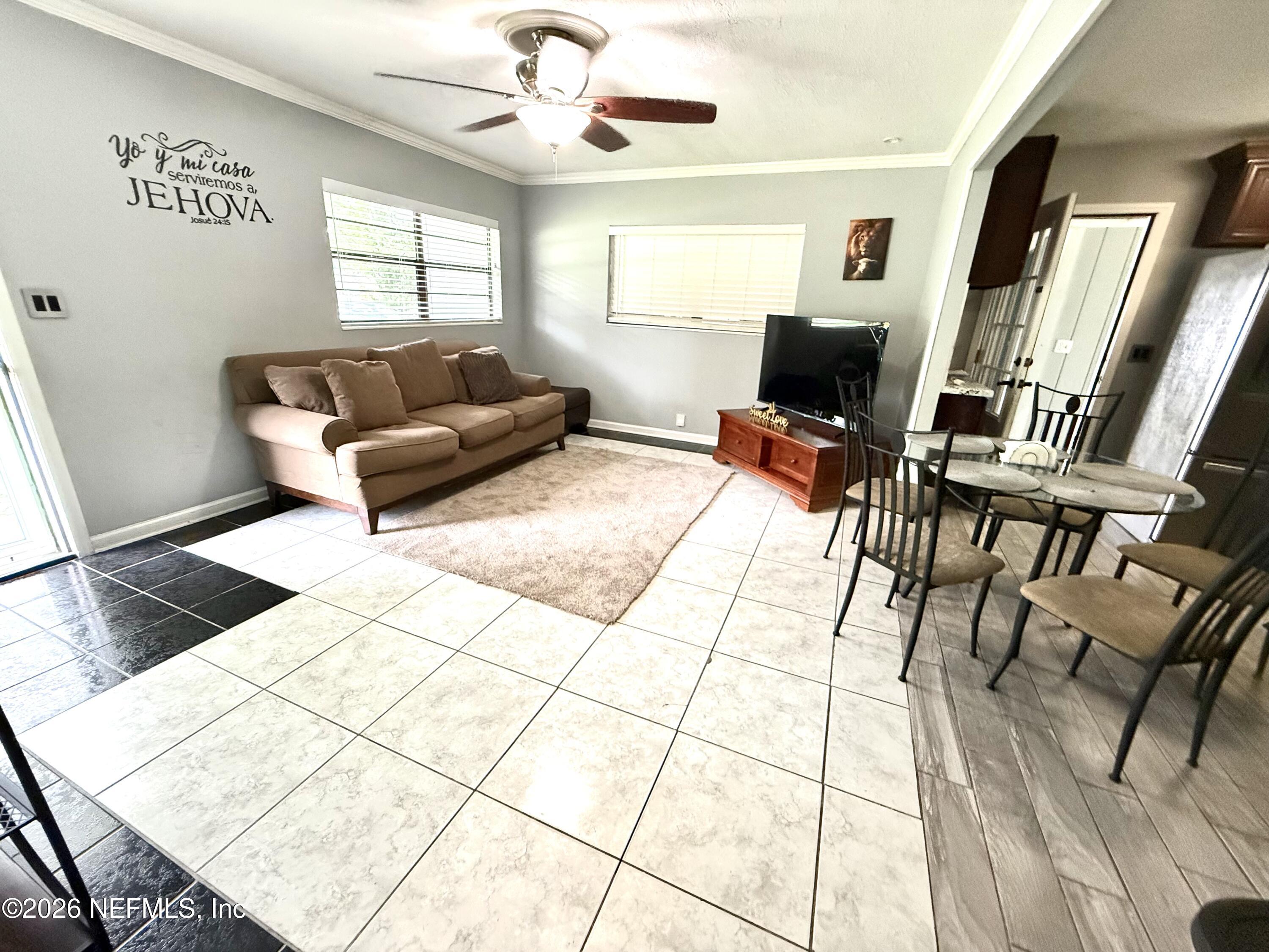 10162 Herndon Road Jacksonville, FL 32246 - Photo 5 of 31 a living room with furniture and a flat screen tv
