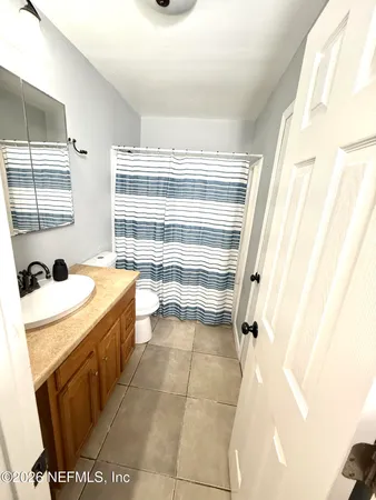 a bathroom with a tub sink and mirror