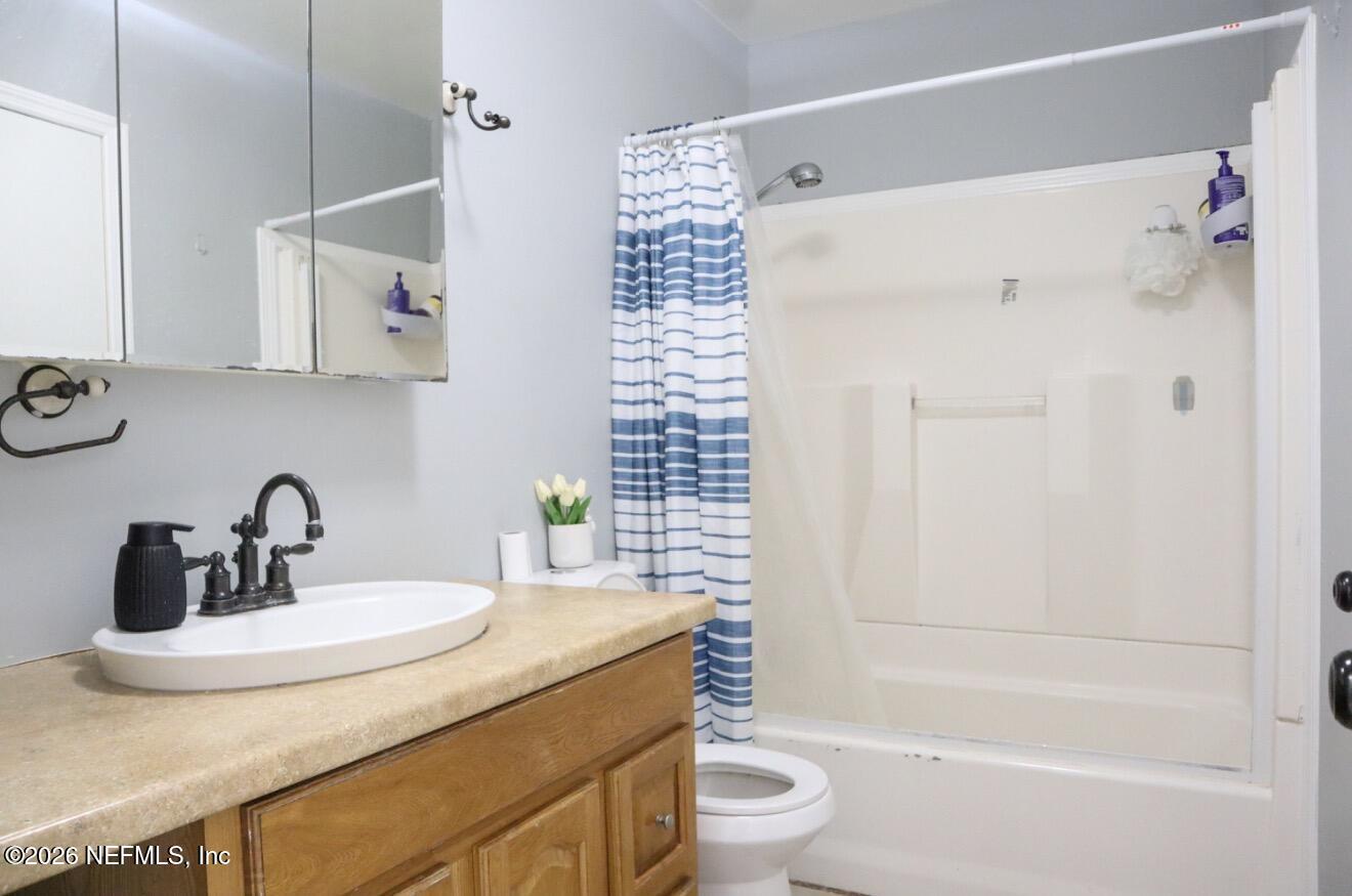 10162 Herndon Road Jacksonville, FL 32246 - Photo 9 of 31 a bathroom with a sink a toilet and shower
