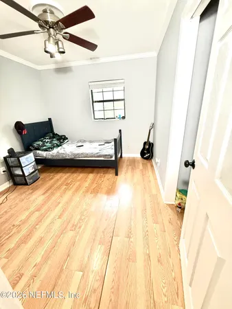 a bedroom with a bed and wooden floor