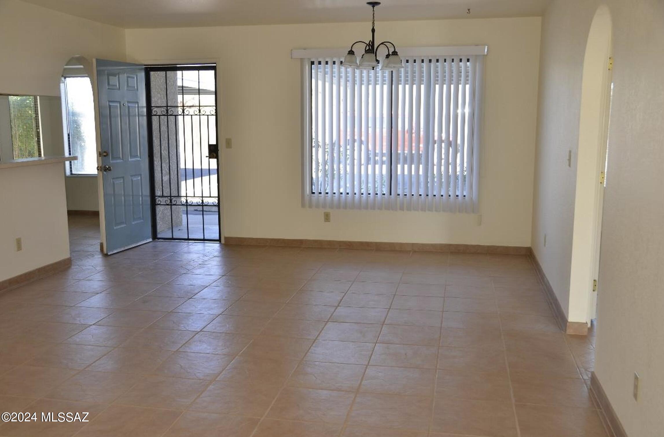 2118 North Ralph Avenue Tucson, AZ 85712 - Photo 7 of 10 an empty room with wooden floor and windows