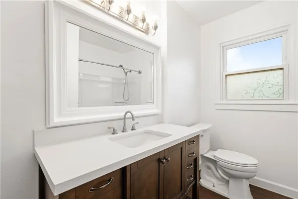 a bathroom with a sink vanity and a toilet