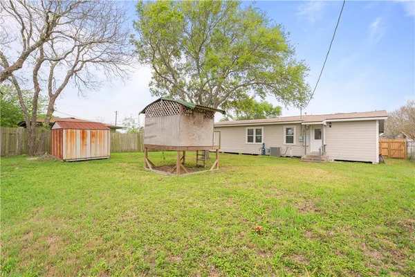 a view of a house with backyard and tree