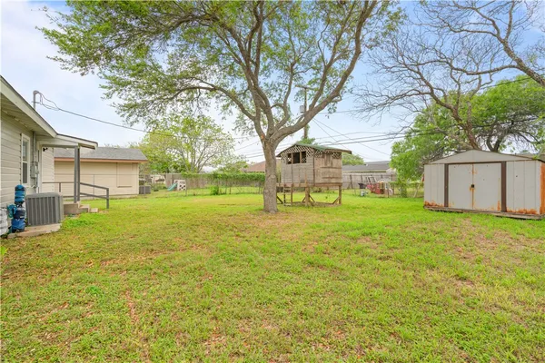 a view of a house with backyard and tree