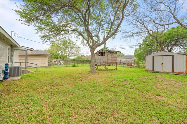 a view of a house with backyard and tree