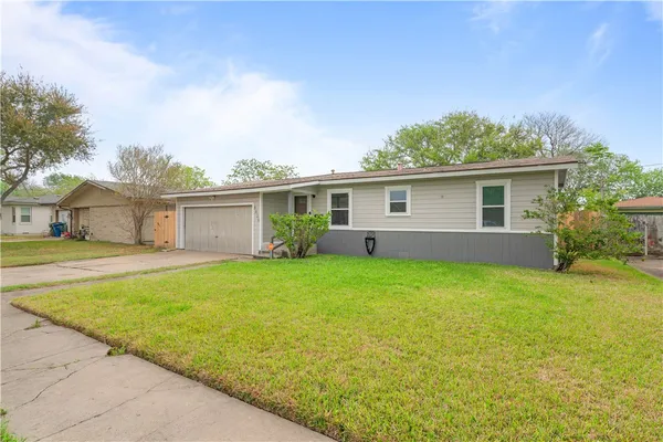 a front view of house with yard and green space