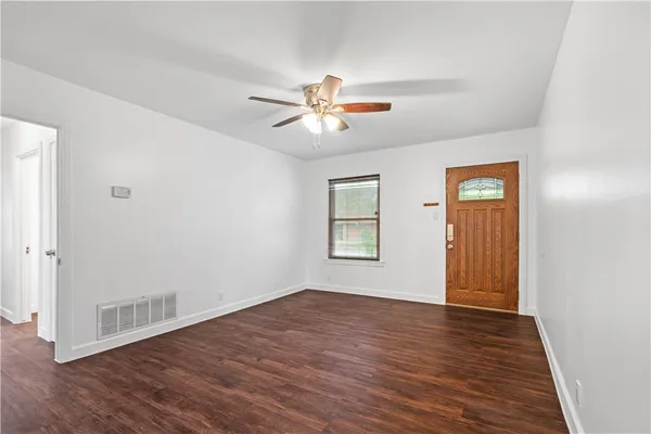 a view of a room with wooden floor and a ceiling fan