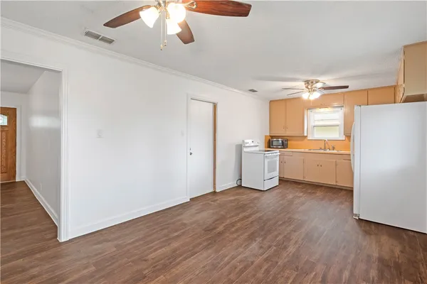 a kitchen with granite countertop a sink cabinets stainless steel appliances and wooden floor