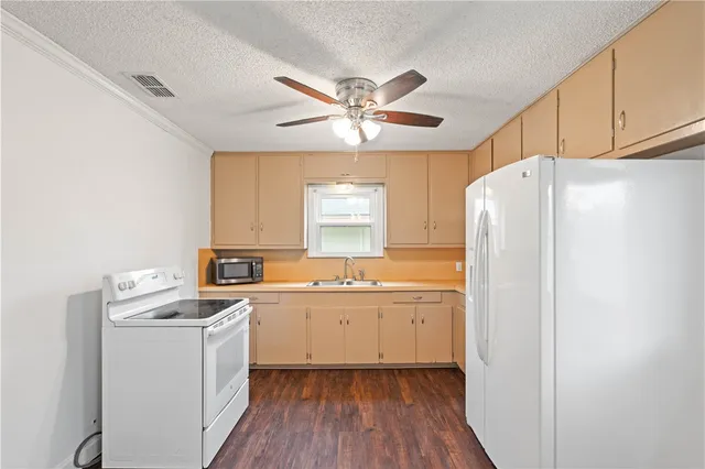 a kitchen with refrigerator cabinets and sink