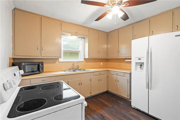 a kitchen with a refrigerator sink and cabinets